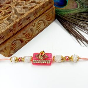 ARNAS 1 PC PINK STONE WITH GOLDEN PEACOCK FEATHER MOTIF DESIGNER RAKHI