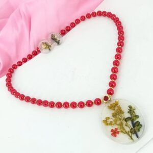 ARNAS COMBO SET OF OPAQUE WHITE RESIN OVAL MOTIF PENDANT & EARRINGS WITH SEA HERBS AND FLORAL DESIGN